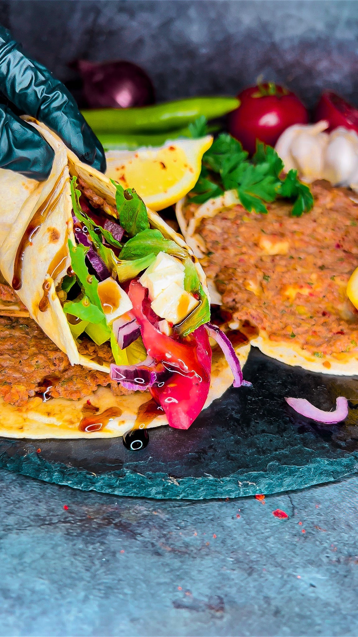 Lahmacun mit Hackfleisch, frischer Petersilie und würziger Tomatensauce, serviert auf Lavash Brot, goldbraun gebacken und mit frischen Zutaten garniert.