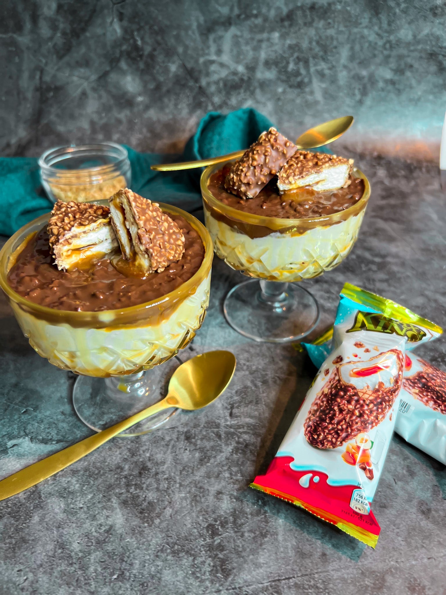 Cremiges Maxi King Dessert in einem Glas, geschichtet mit Mascarpone-Creme, Nutella, Karamellsoße und garniert mit gehackten Haselnüssen und Maxi King Stückchen.