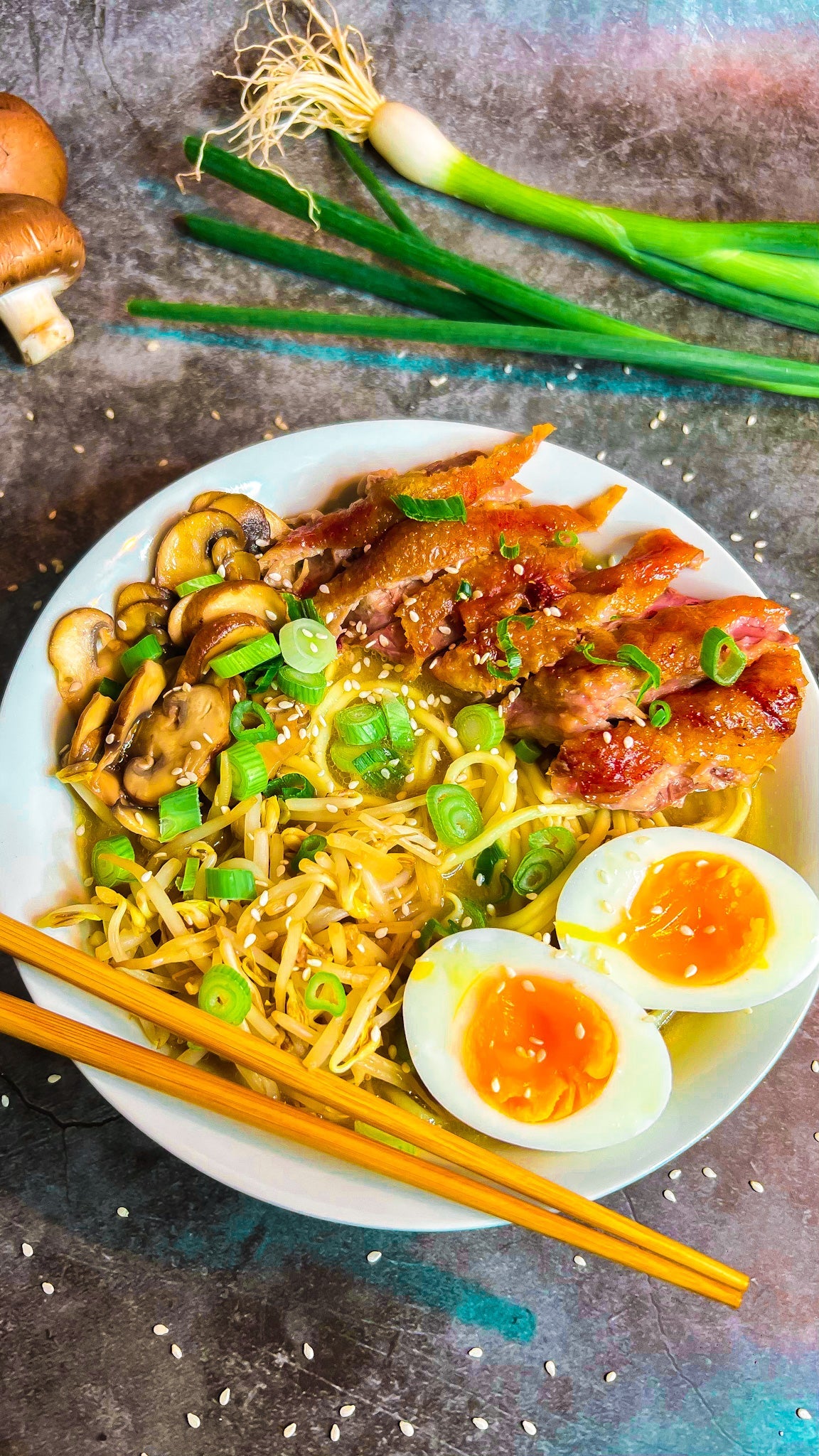 Ein Teller Ramen-Nudelsuppe mit Champignons, Sojasprossen, Frühlingszwiebeln, Ei und Sesamöl.