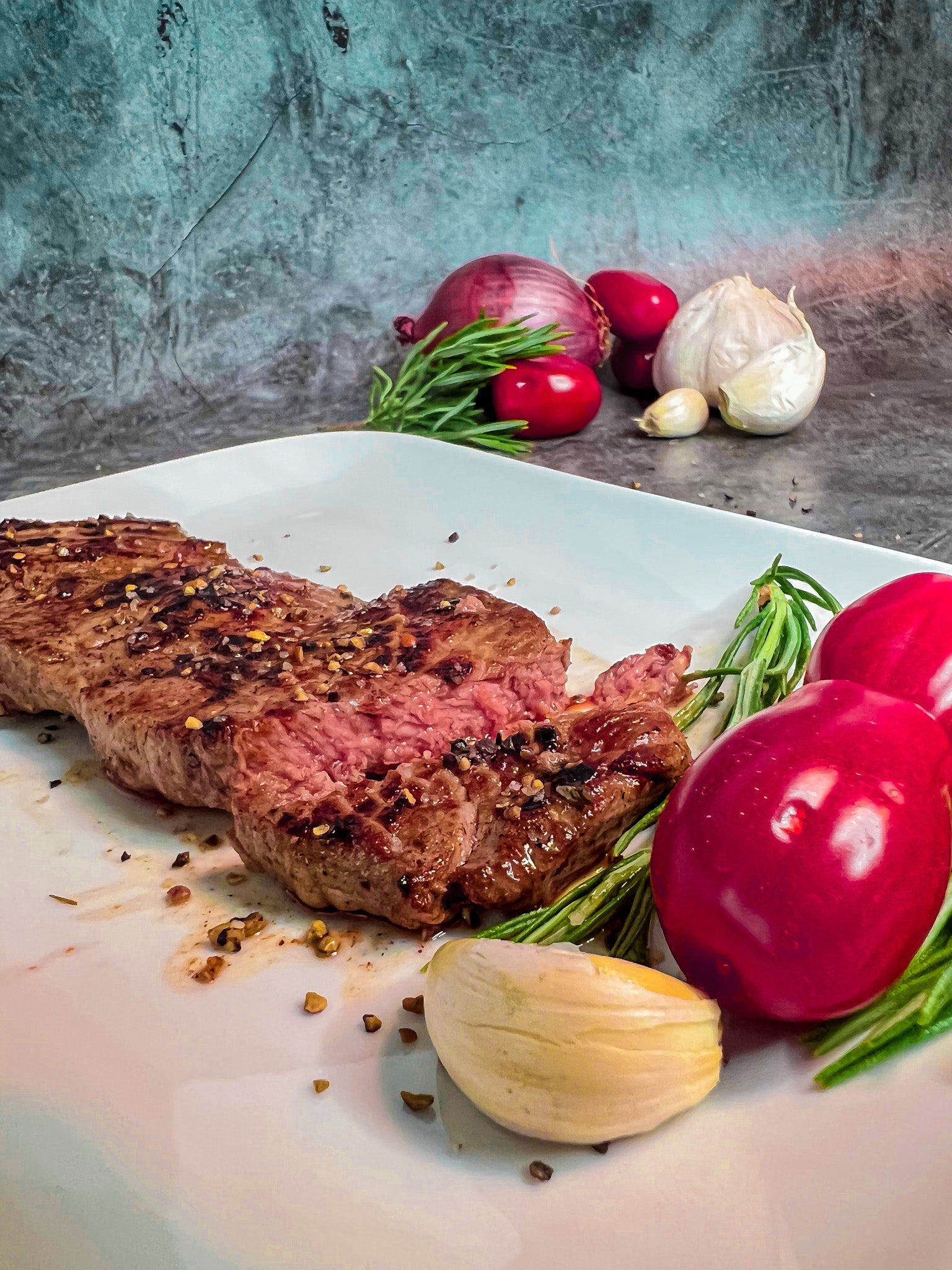 Ein saftig gebratenes Steak in einer Pfanne mit geschmolzener Butter, Knoblauch und Rosmarin.