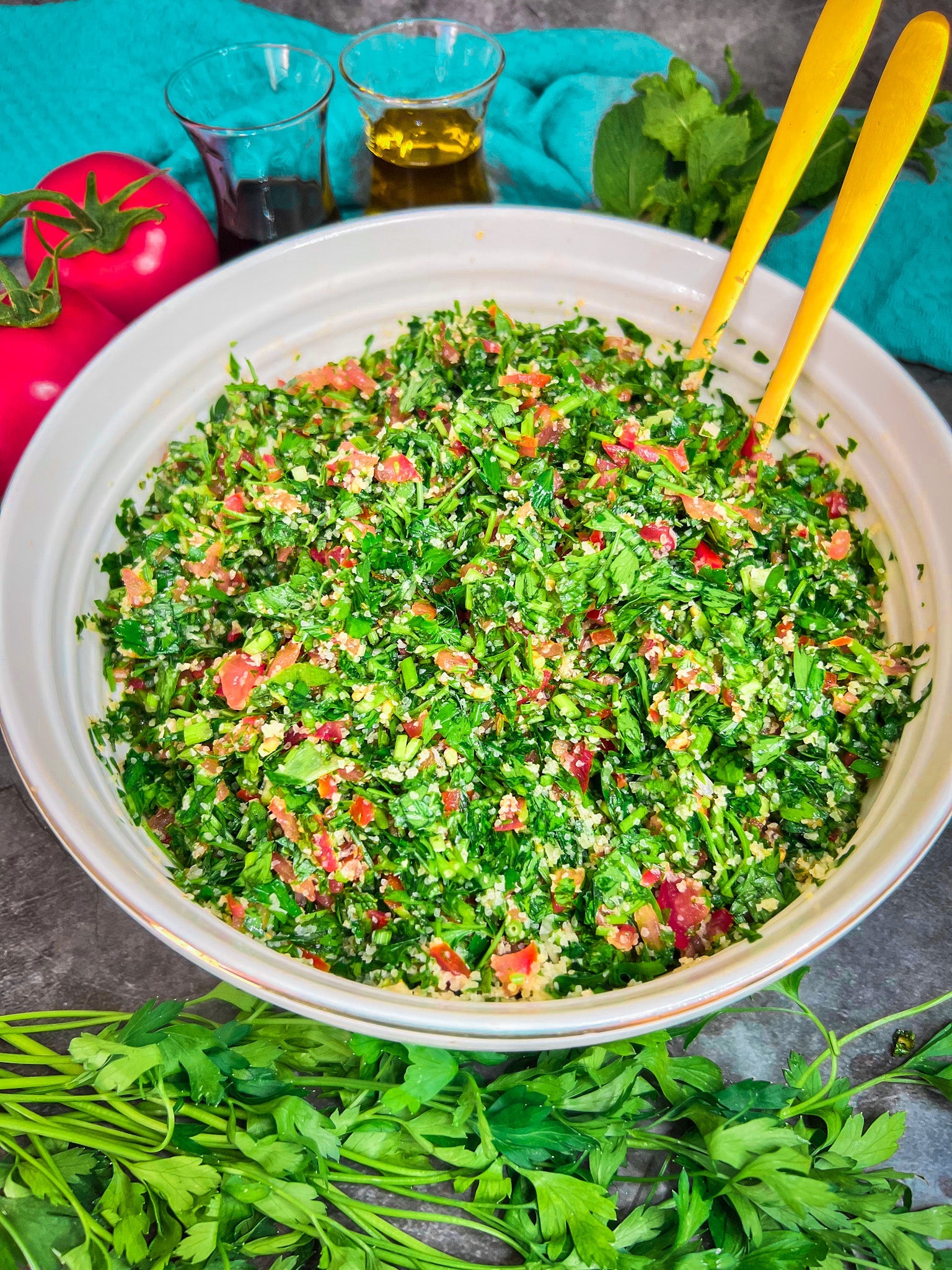 Ein frischer Tabule-Salat, serviert in einer Schüssel, garniert mit Zitronenscheiben und Minzblättern.