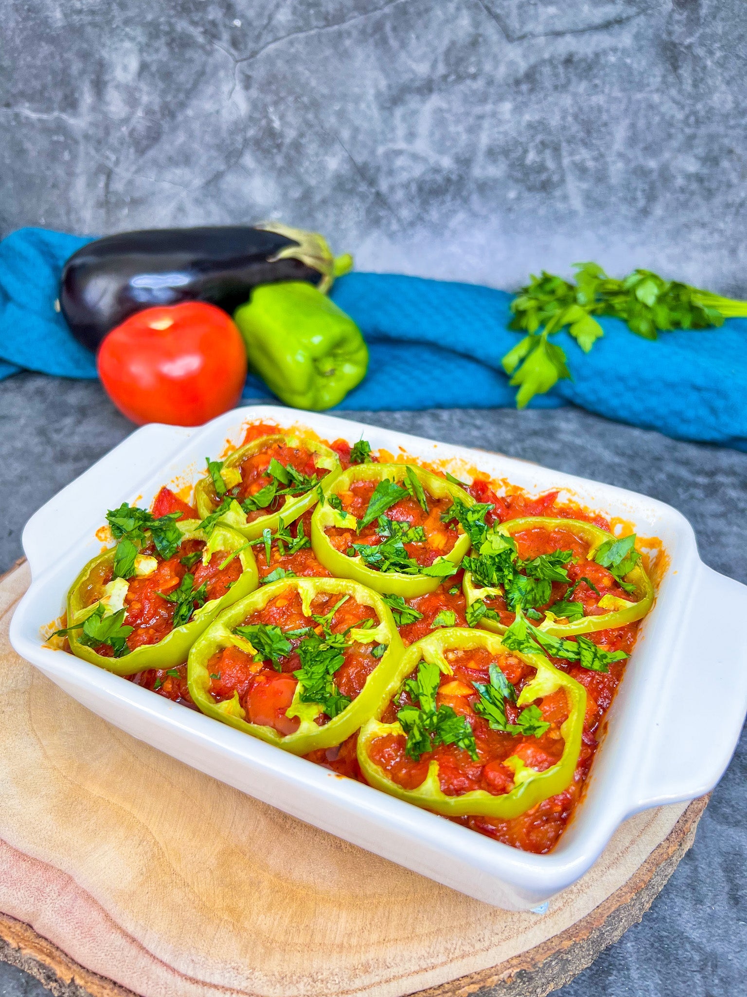 Musaka’a in einer Auflaufform, geschichtet mit Auberginen, Tomatensoße und frischen Paprikaringen.