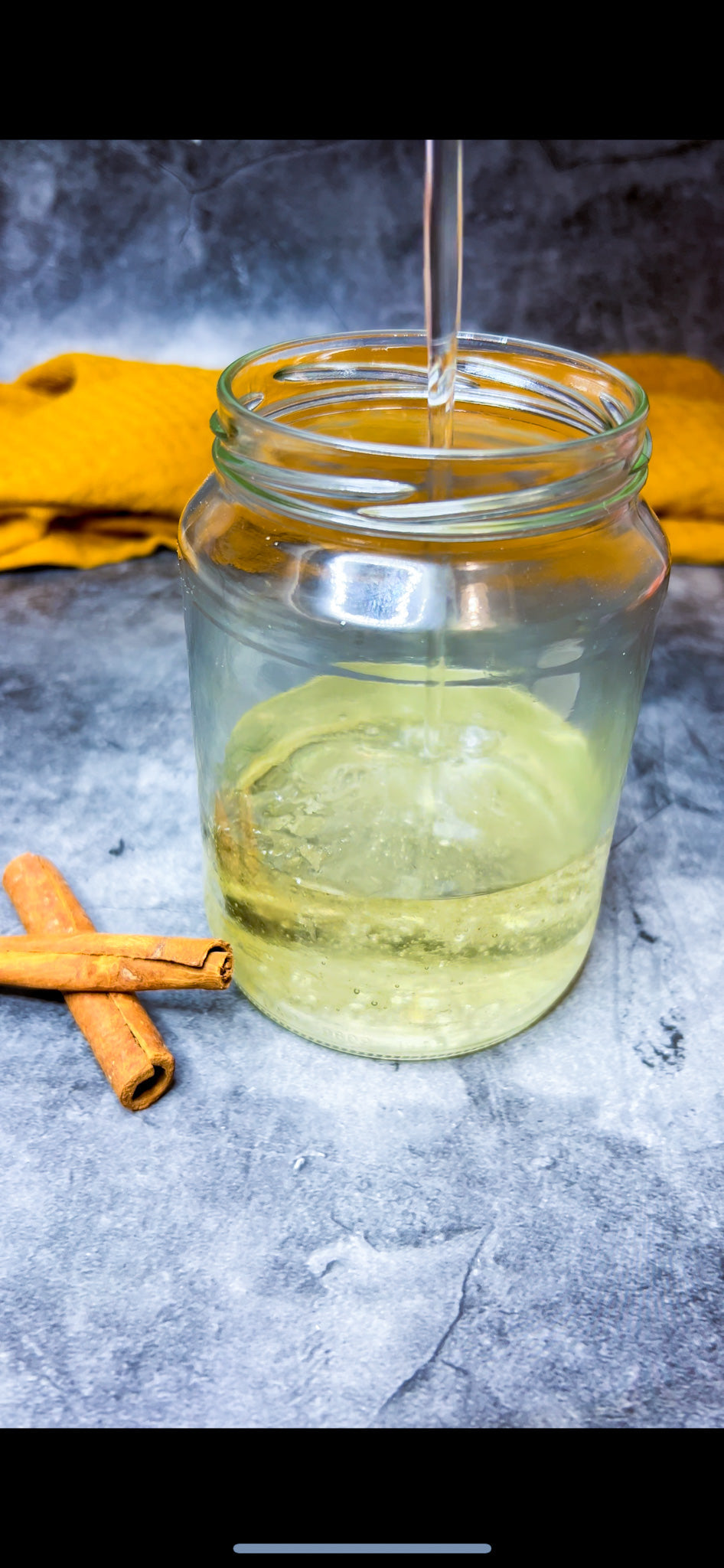 Ein Glas mit hausgemachtem Ater (Zuckersirup), dekoriert mit einer Zimtstange und Orangenblüten.