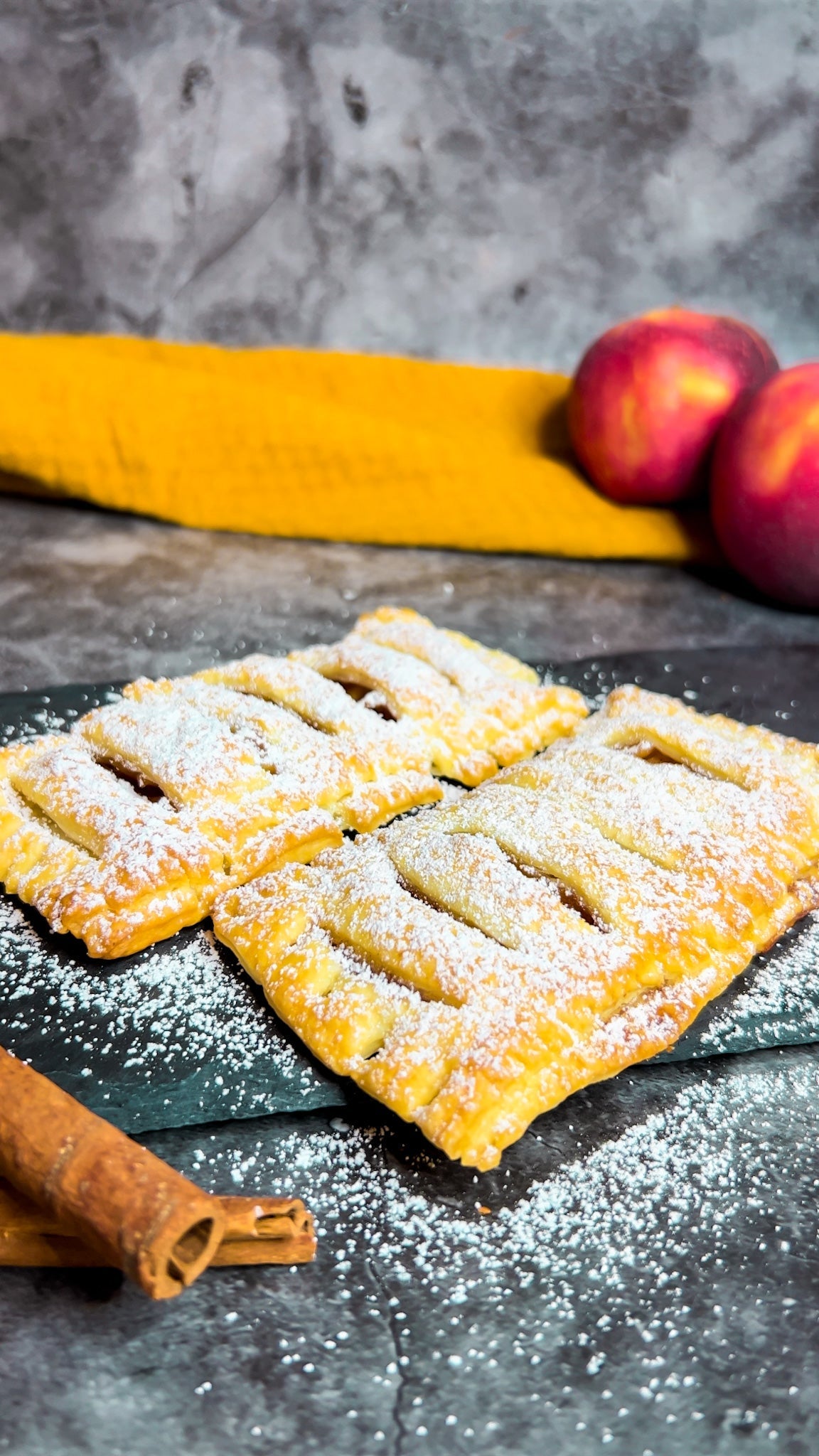 Frisch gebackene Apfeltaschen, mit Puderzucker bestäubt, serviert auf einem Teller.