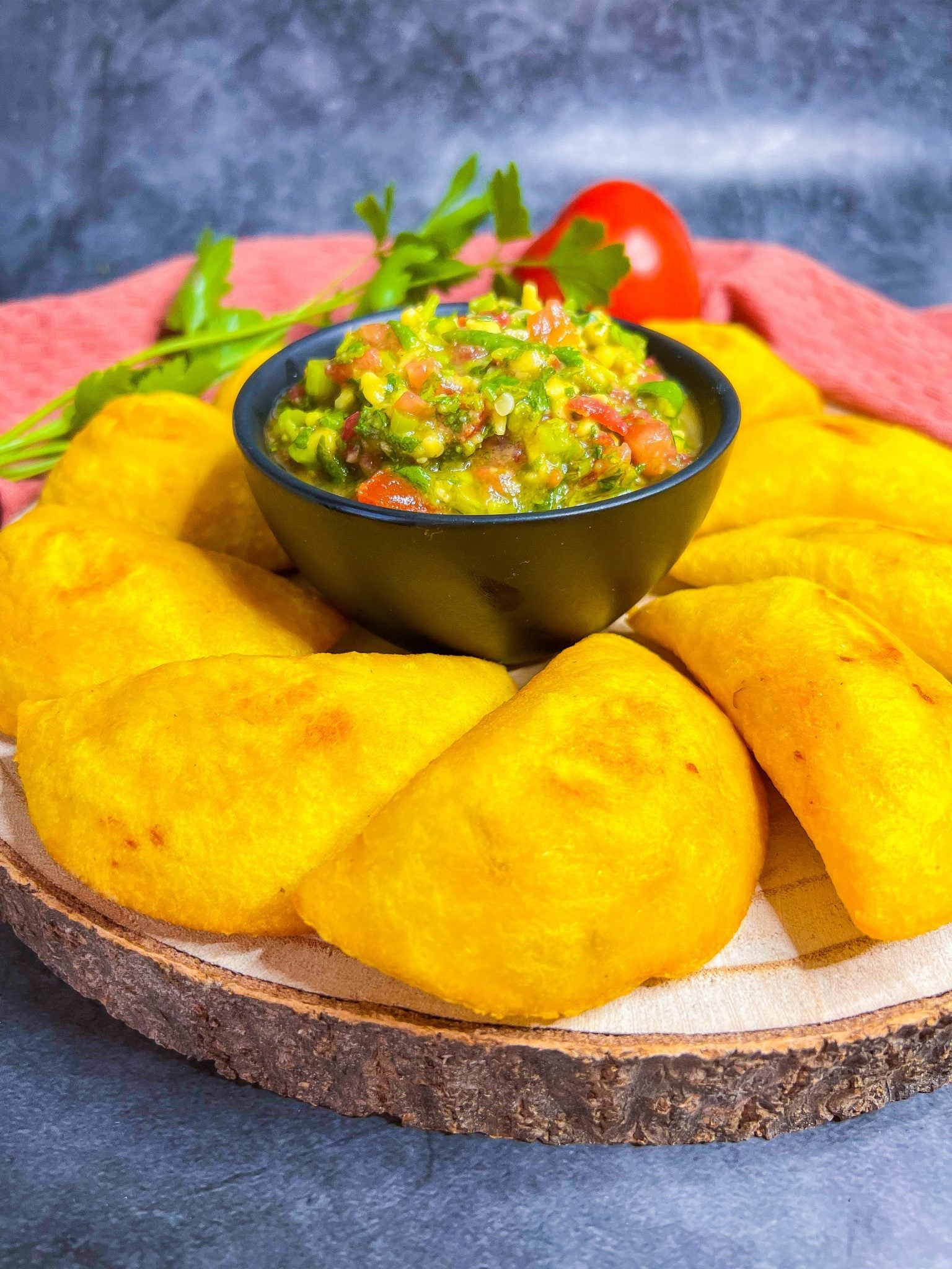 Knusprige Empanadas de Cali, serviert mit einer pikanten Soße und Limettenspalten.