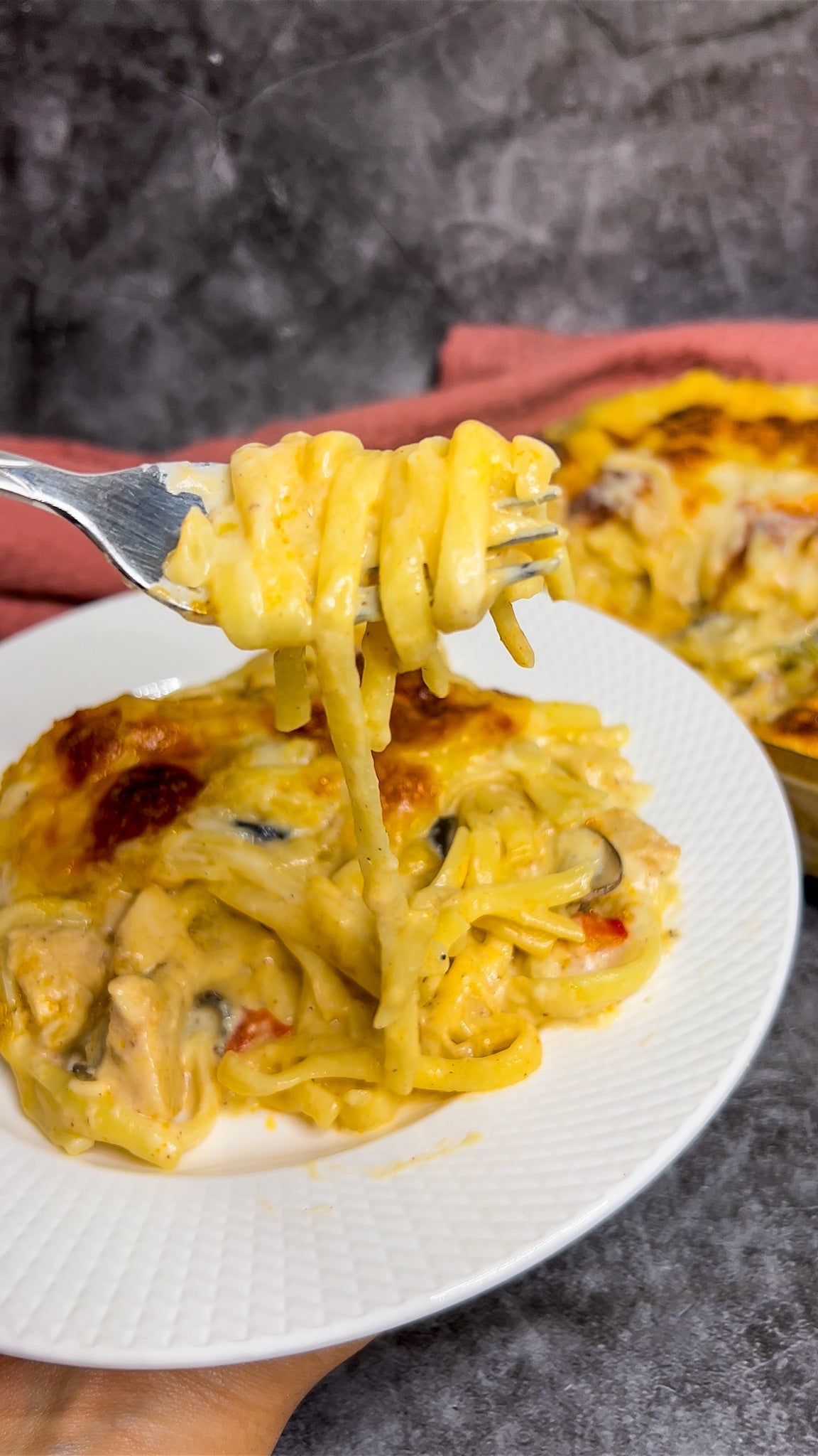 Chicken Negresco Pasta, überbacken mit goldbraunem Käse, serviert in einer Auflaufform.