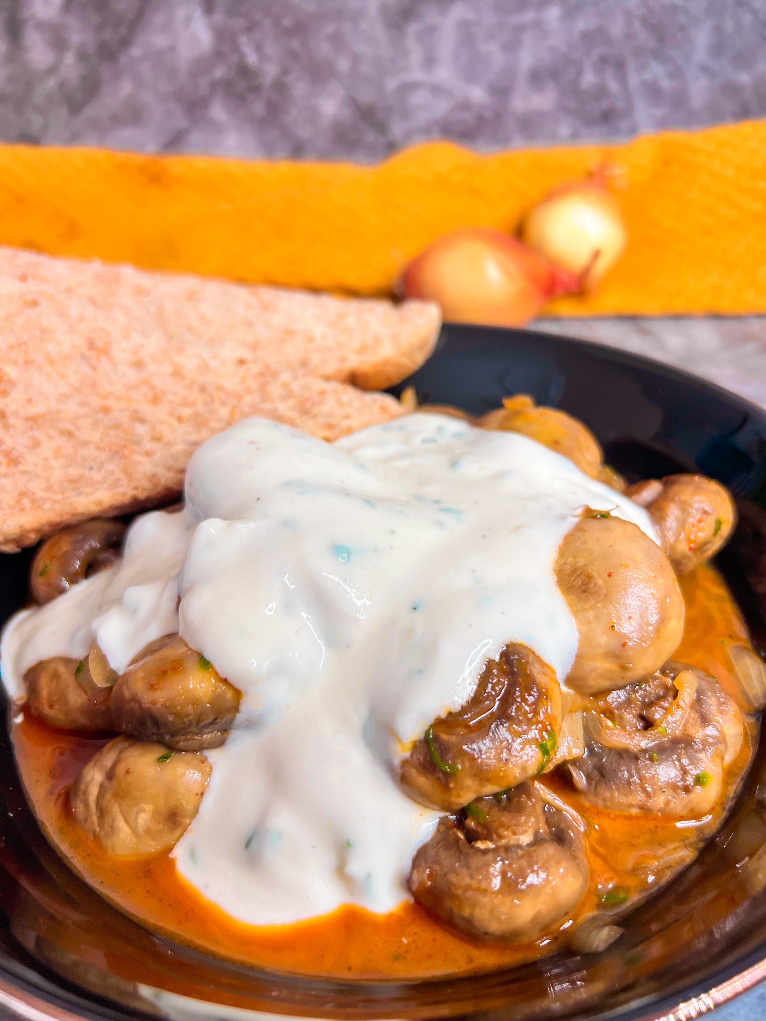 Würzig gebratene Champignons mit Zwiebeln, serviert mit cremiger Knoblauch-Joghurt-Soße.