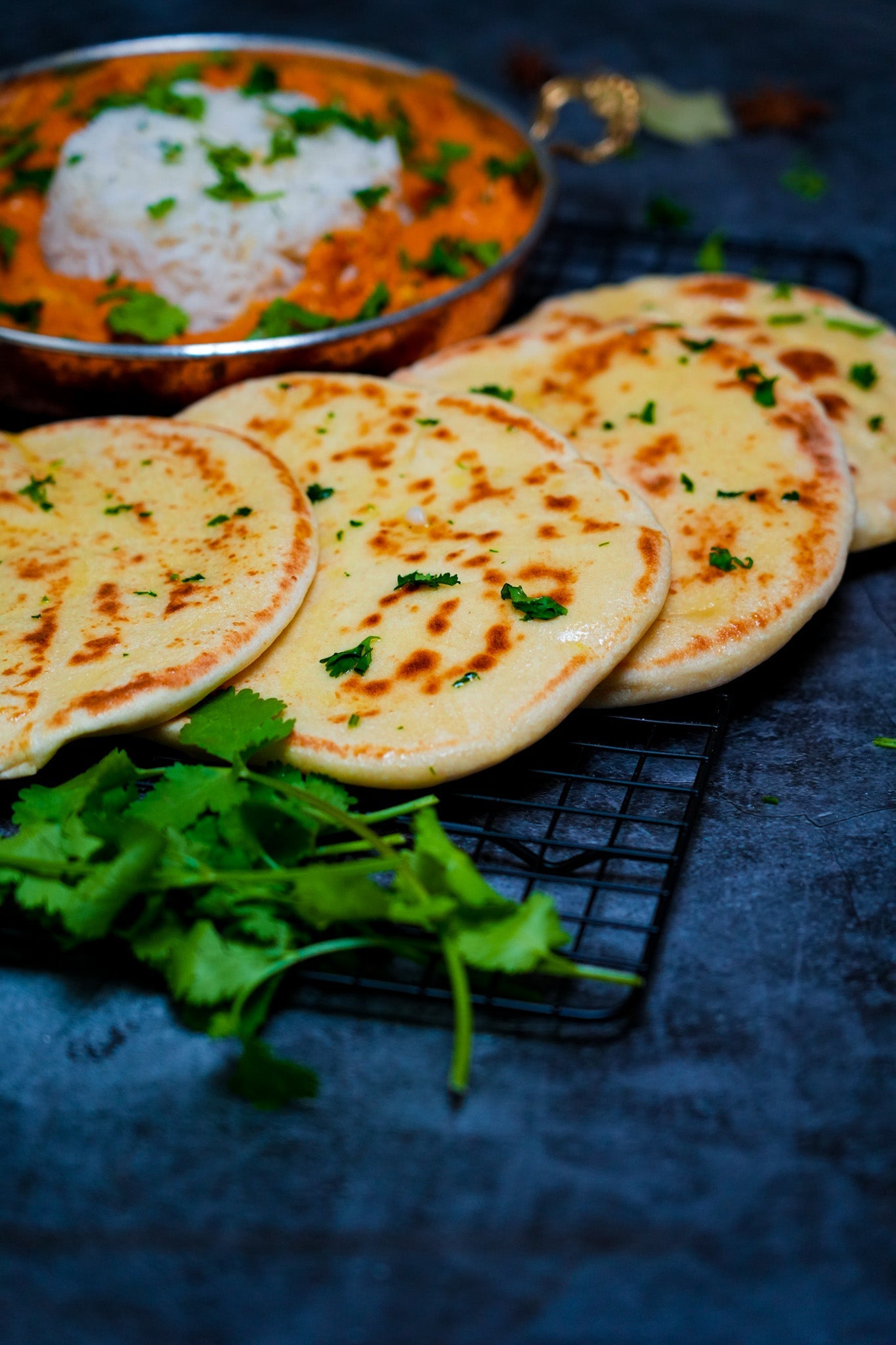 Indisches Naan-Brot, frisch aus der Pfanne, bestrichen mit Butter, Knoblauch und gehacktem Koriander.