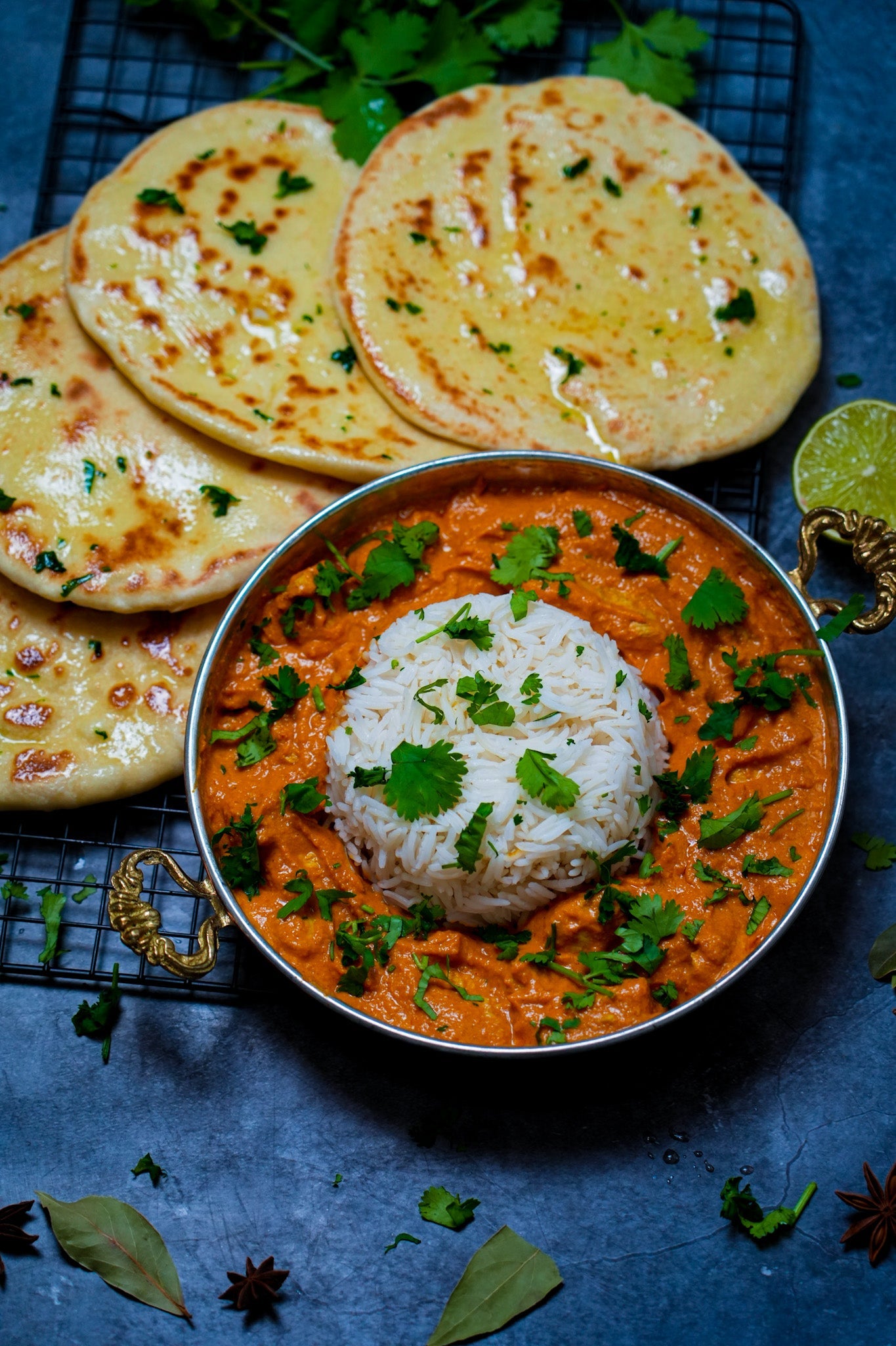 Indisches Butter Chicken, serviert mit Reis und frischem Koriander, in einer cremigen Tomatensoße.