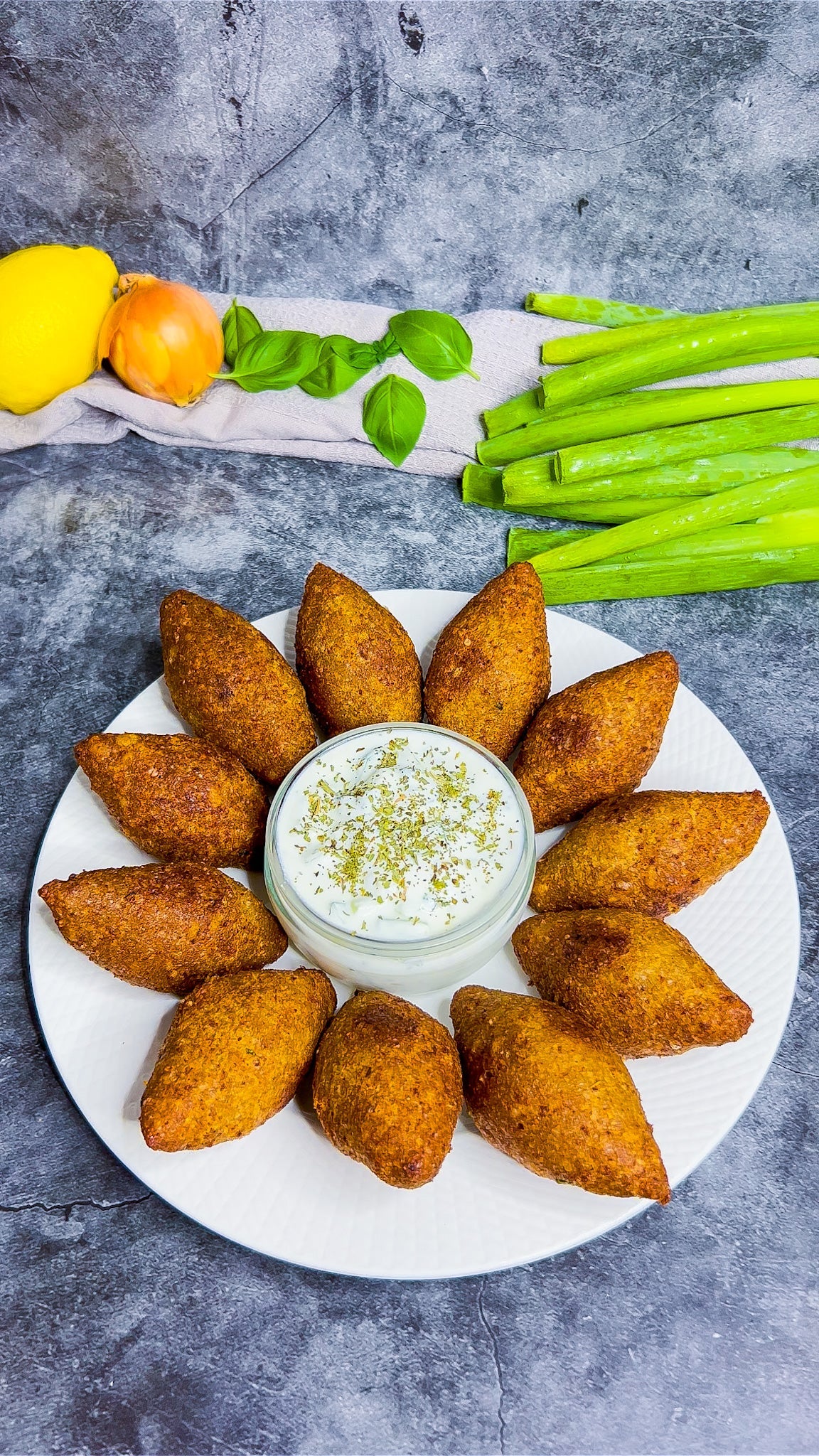 Kibbeh – knusprig frittierte Fleischbällchen mit Bulgur, serviert mit einer erfrischenden Joghurtsoße.