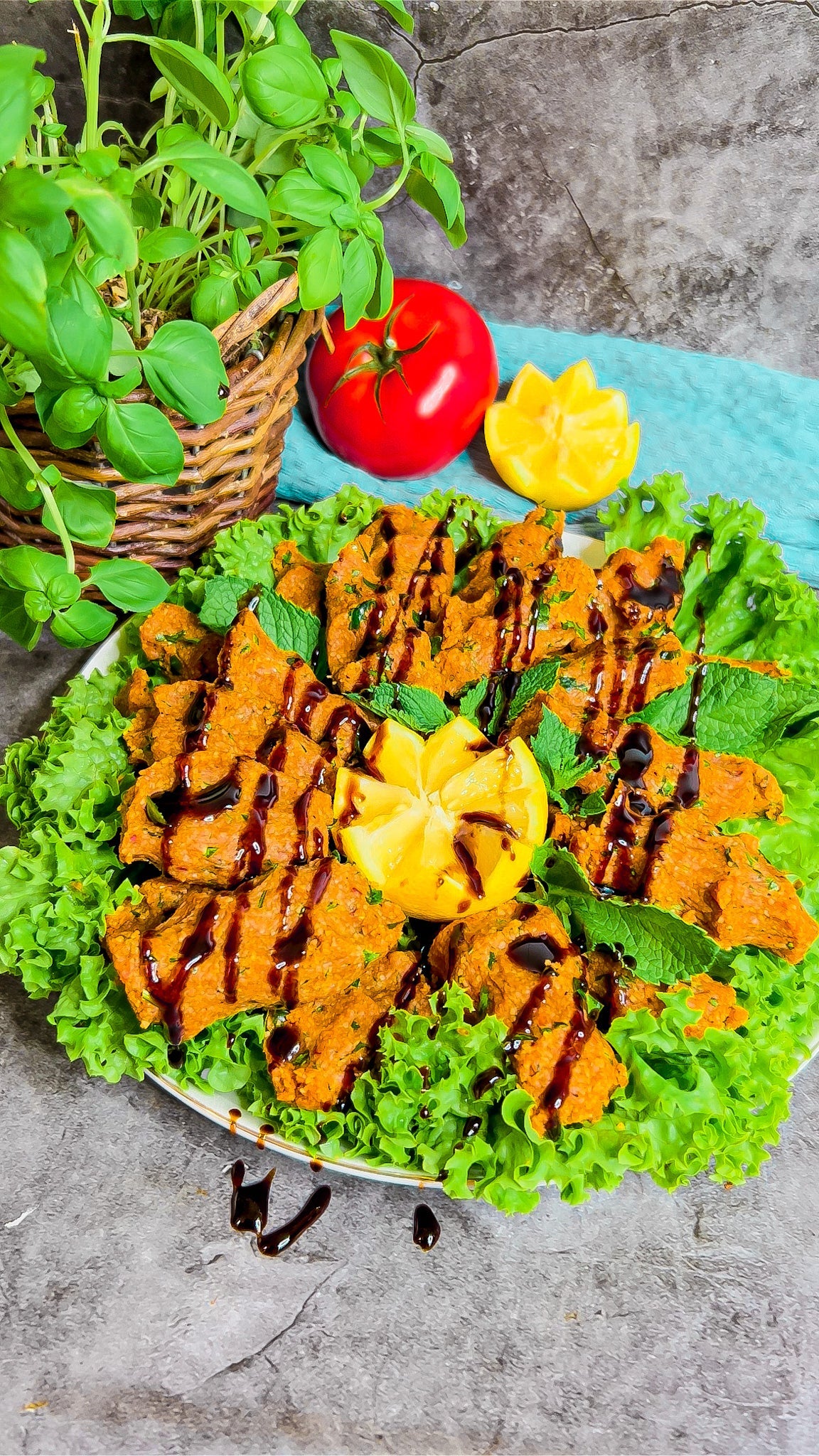 Veganes Çiğ Köfte, angerichtet mit frischen Kräutern und Beilagen.