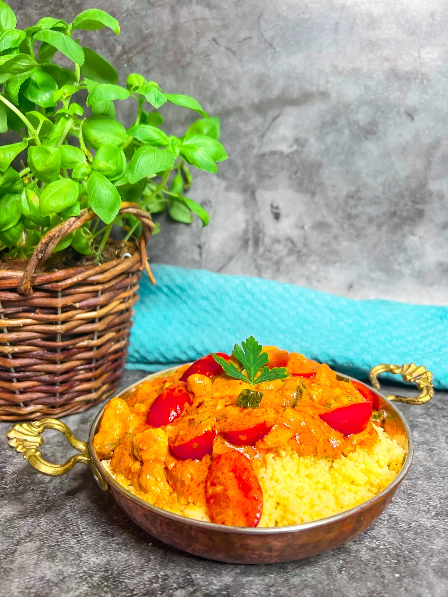 Lachsfilet mit Couscous und Gemüse in einer cremigen Tomaten-Kokosmilch-Soße.