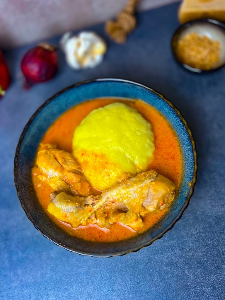 Fufu serviert mit cremiger Erdnusssuppe und saftigem Hähnchen.